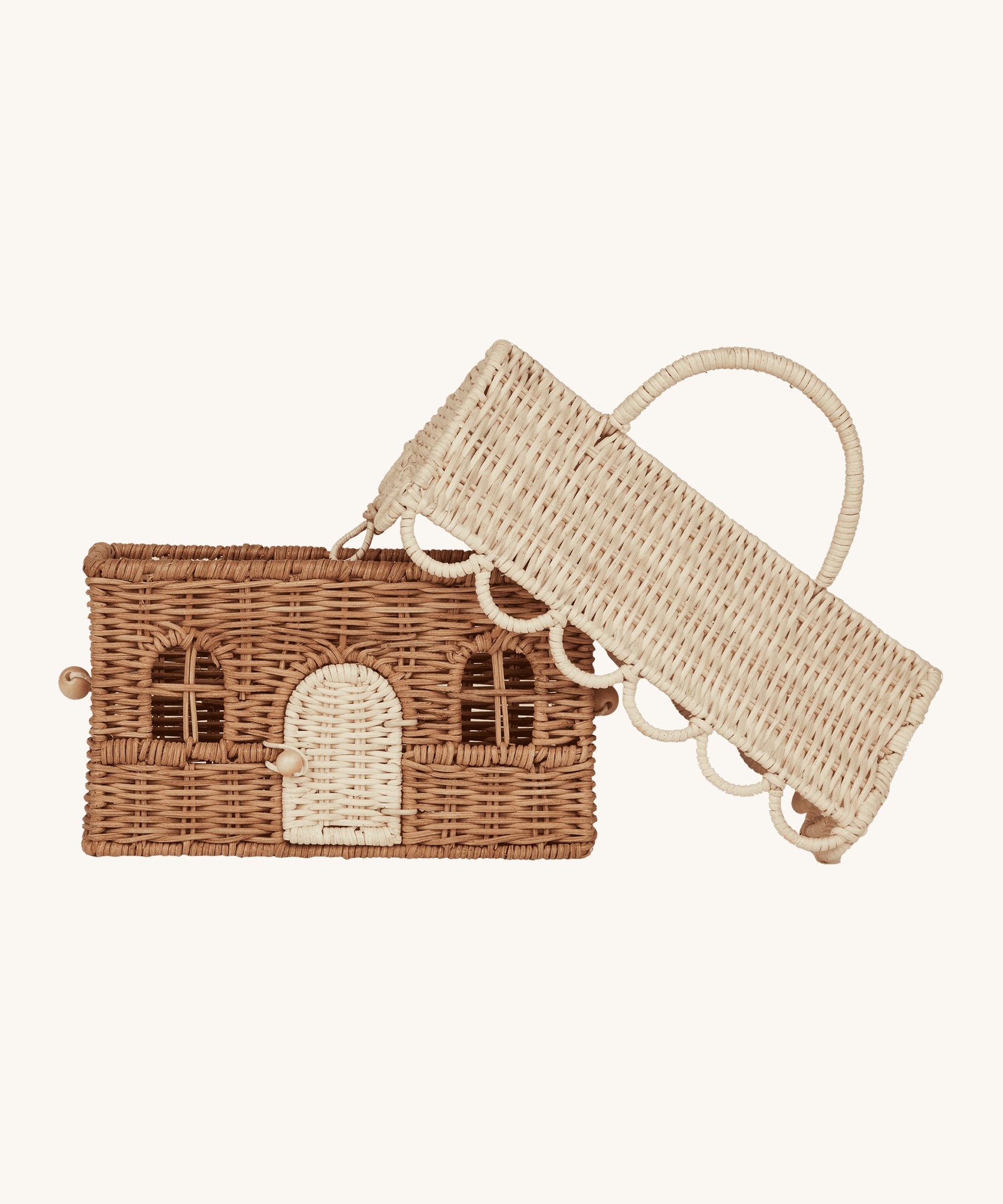 The Olli Ella Olli Ella Rattan Gingerbread House Basket with the lid leaning against the side of the basket