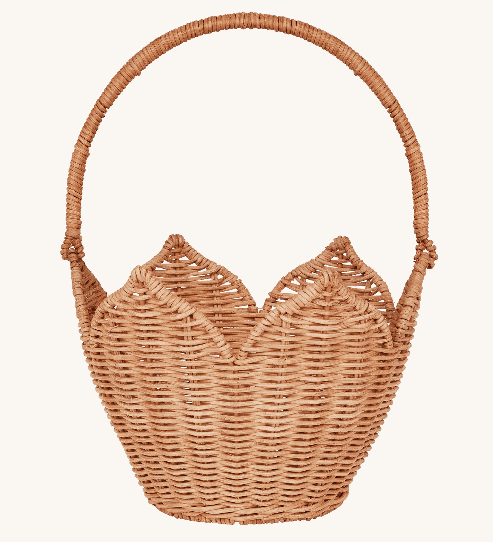 Olli Ella Rattan Poinsettia Carry Basket is a beautiful scalloped, handwoven, rattan basket in a light brown, with a carry handle. The basket is on a cream background.