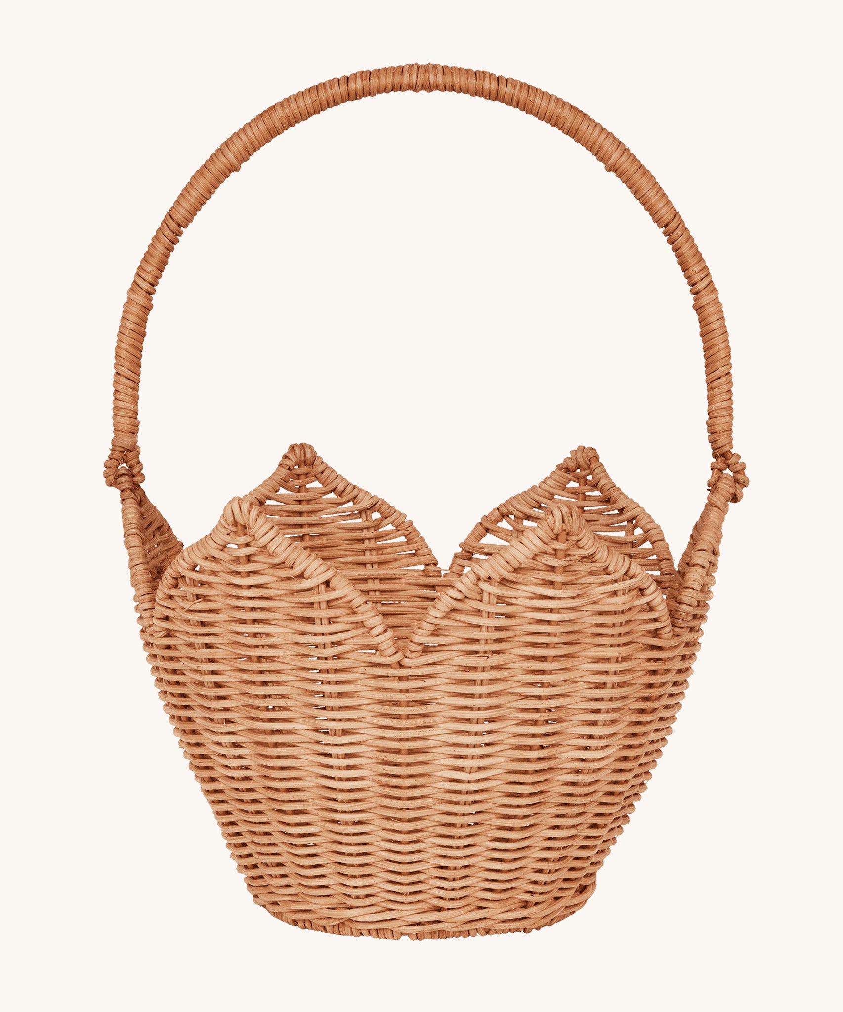 Olli Ella Rattan Poinsettia Carry Basket is a beautiful scalloped, handwoven, rattan basket in a light brown, with a carry handle. The basket is on a cream background.