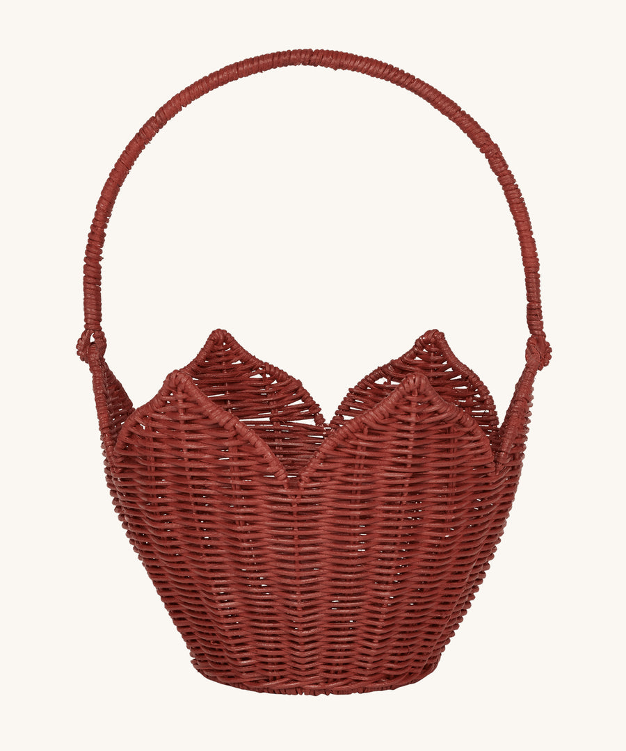 Olli Ella Rattan Poinsettia Carry Basket is a beautiful scalloped, handwoven, rattan basket in a poinsettia red colour, with a carry handle. The basket is on a cream background.