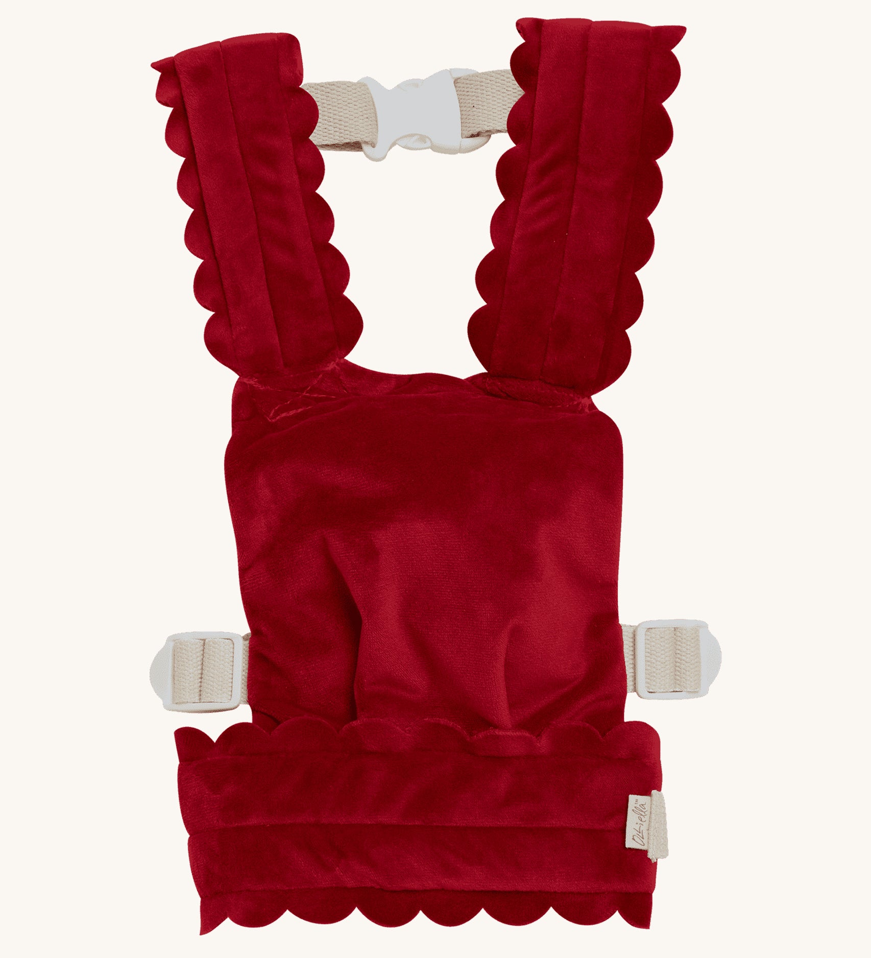 Olli Ella Dinkum Dolls Petal Carrier in Red Velvet, has scalloped petal shaped straps and waist band, adjustable straps and can be worn on the front and the back. The image is on a cream background