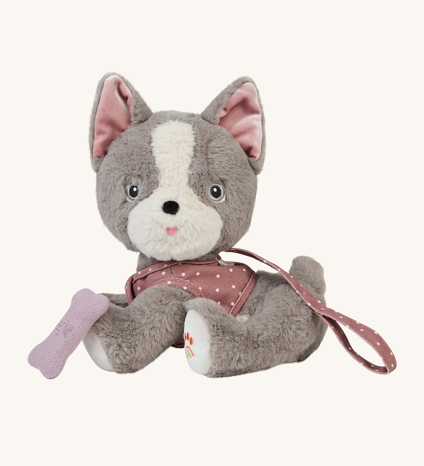 Olli Ella Dinkum Dog - Gizmo is an adorable, soft dog with grey and white plush fur, and wears a dark pink harness with white spots, and has a plush dark pink bone