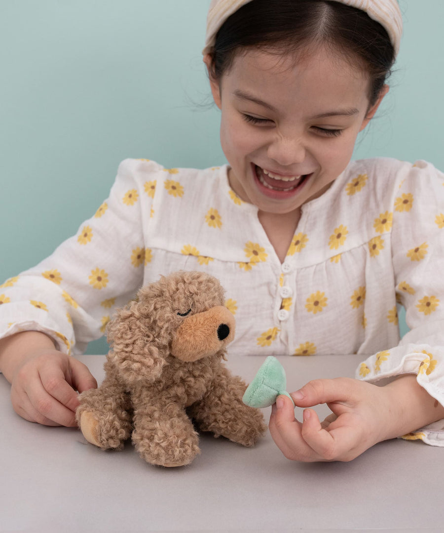 A child playing with the Olli Ella Benny the dinkum puppy