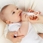 A parent using the Haakaa Oral Feeding Syringe with their child. The syringe tip is in the babies mouth a the parent is pushing the syringe plunger with their thumb