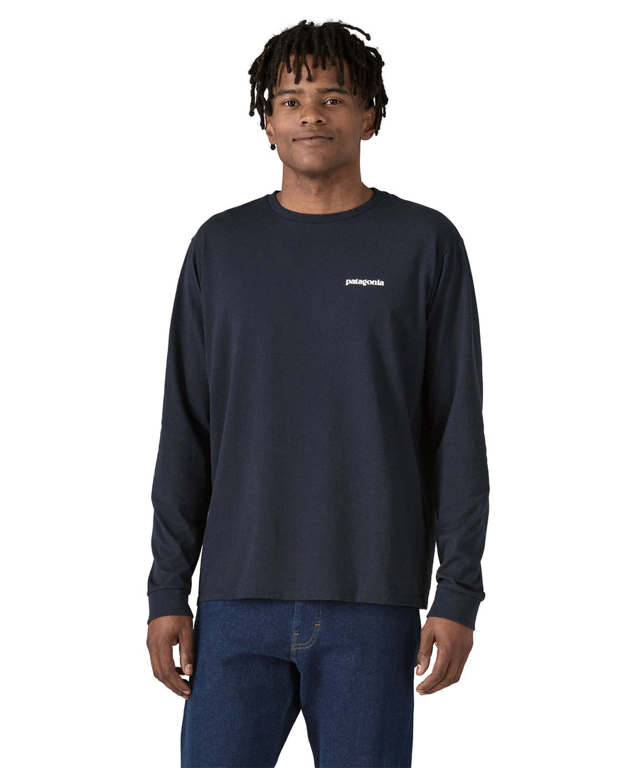 A person wearing the Patagonia L/S P-6 Logo Responsibili-Tee - New Navy, showing the fit from the front