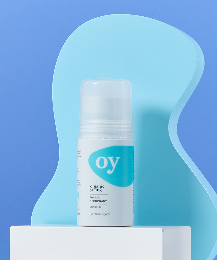 The Green People OY! Organic Teen Deodorant on a wavy blue background, and stood on a white box shelf