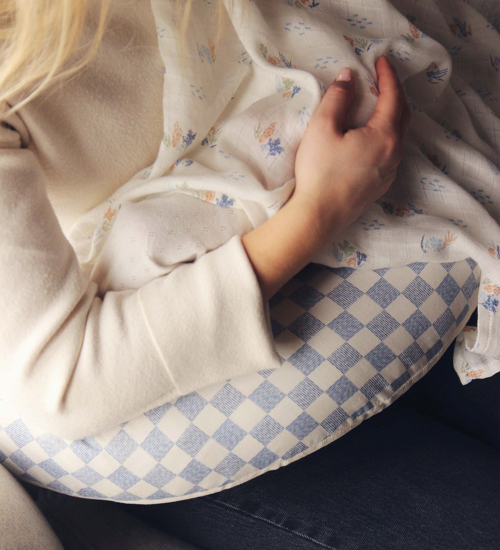 A mother feeding her baby on an Avery Row Nursing Pillow - Waves.