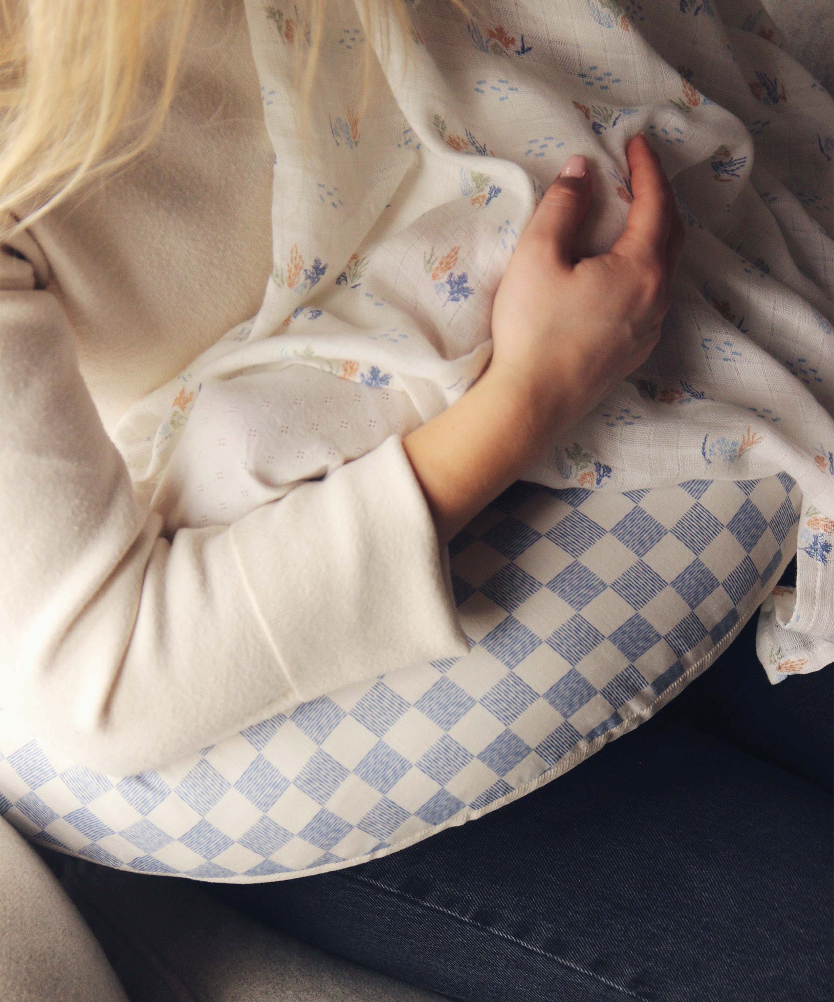 A mother feeding her baby on an Avery Row Nursing Pillow - Waves.