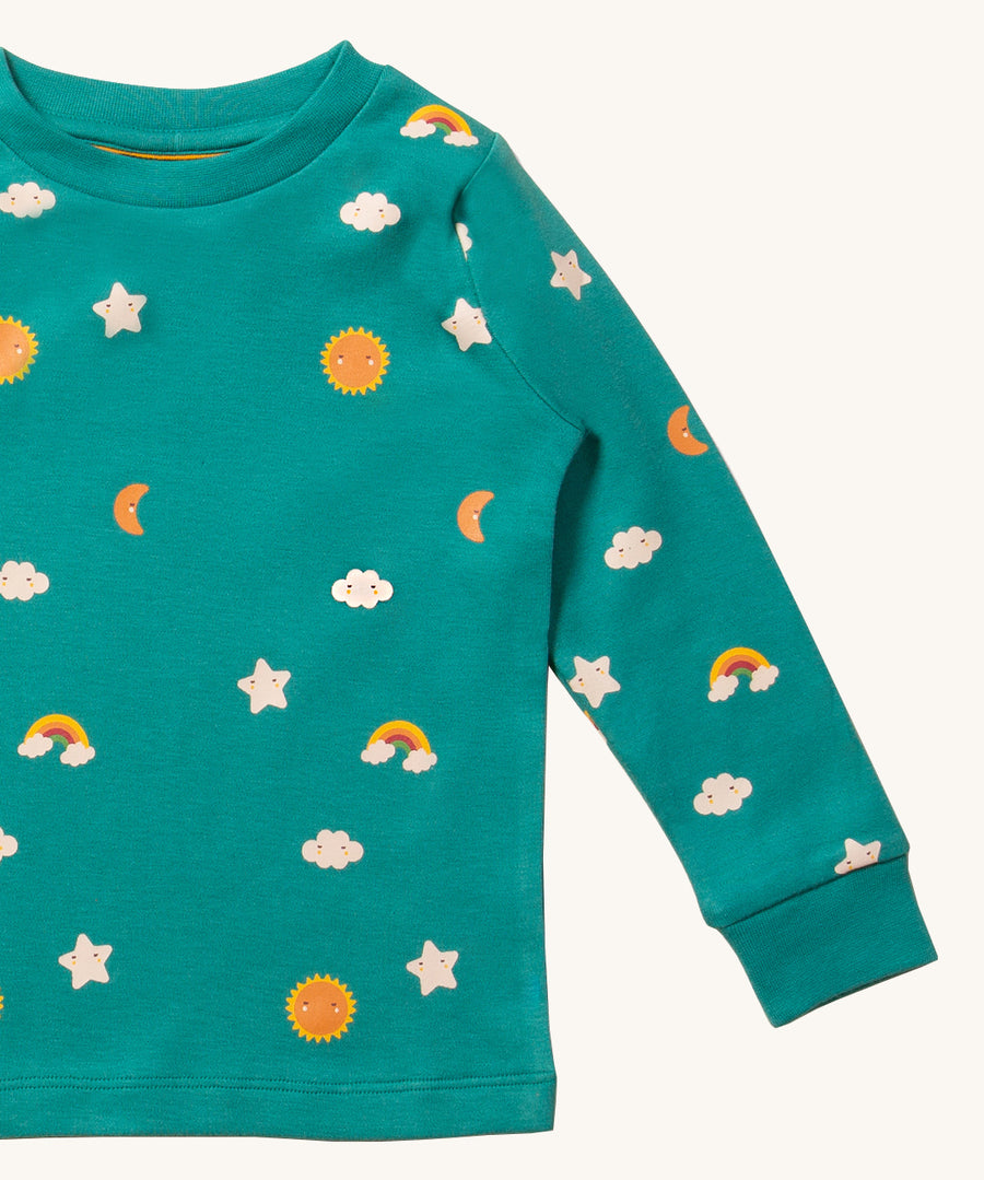 A closer look at the fun and cute rainbow, star, moon and sun print on the Little Green Radicals Organic Pyjama Top - Turquoise Skies