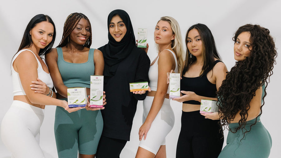 Six women in athletic wear holding Organyc menstrual products, such as pads and tampons