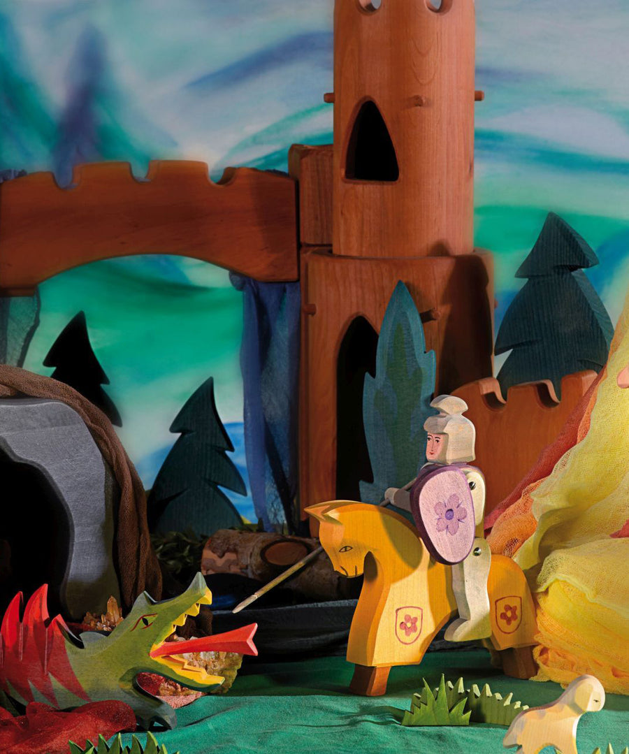 The Ostheimer Wooden Toy Red Riding Knight fighting off an Ostheimer dragon, in a magical fairytale scene