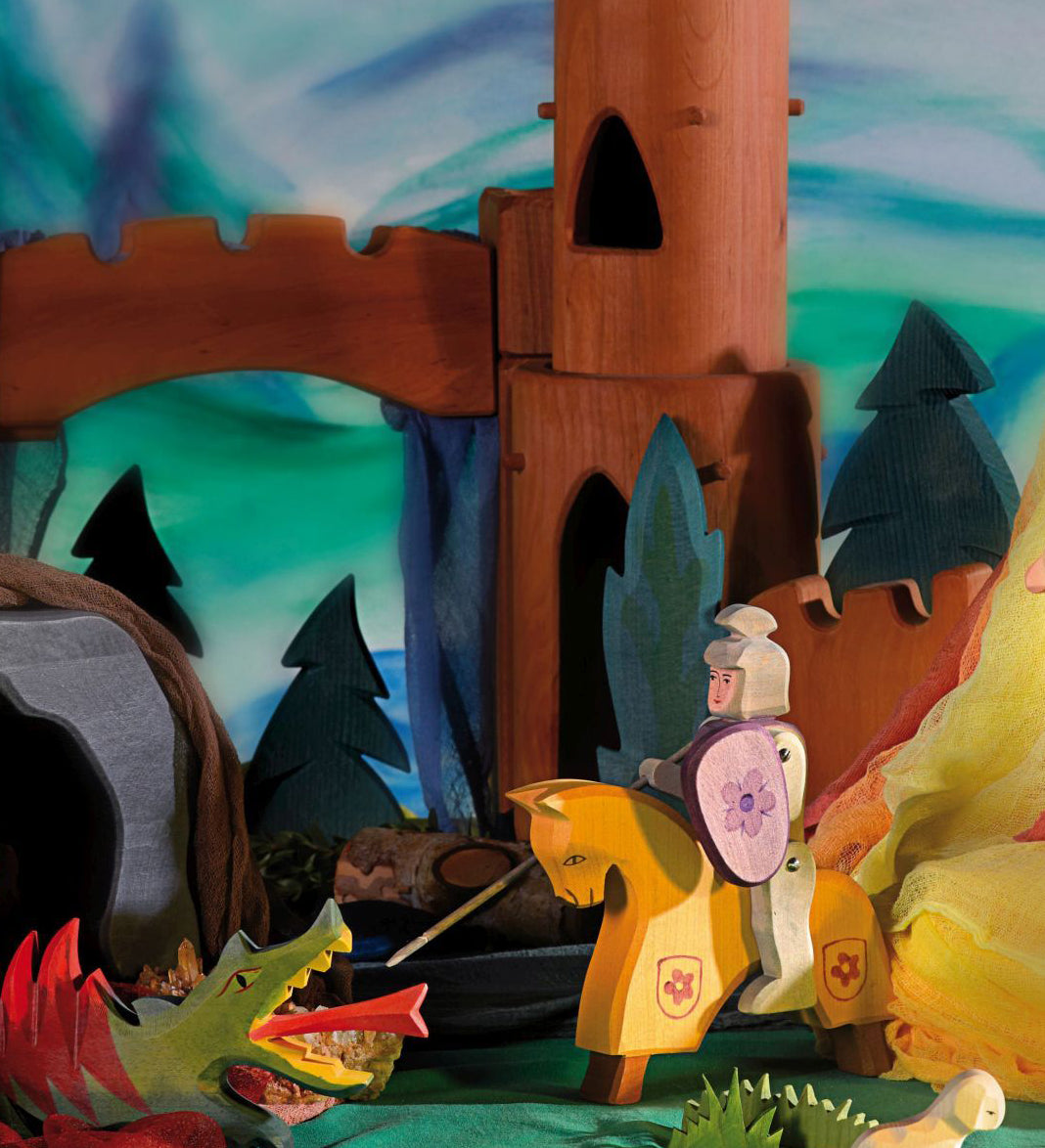 The Ostheimer Wooden Toy Red Riding Knight fighting off an Ostheimer dragon, in a magical fairytale scene