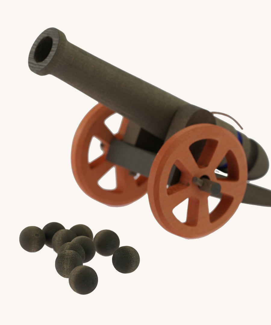 the 10 wooden cannon balls from the Ostheimer Large Cannon set with the cannon in the background pictured on a plain background