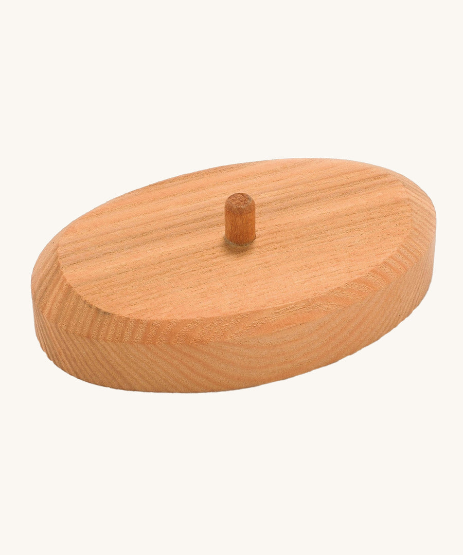 The wooden support stand for the palm tee, in natural wood with a dowel in the middle. The image shows the natural wood grain of the stand