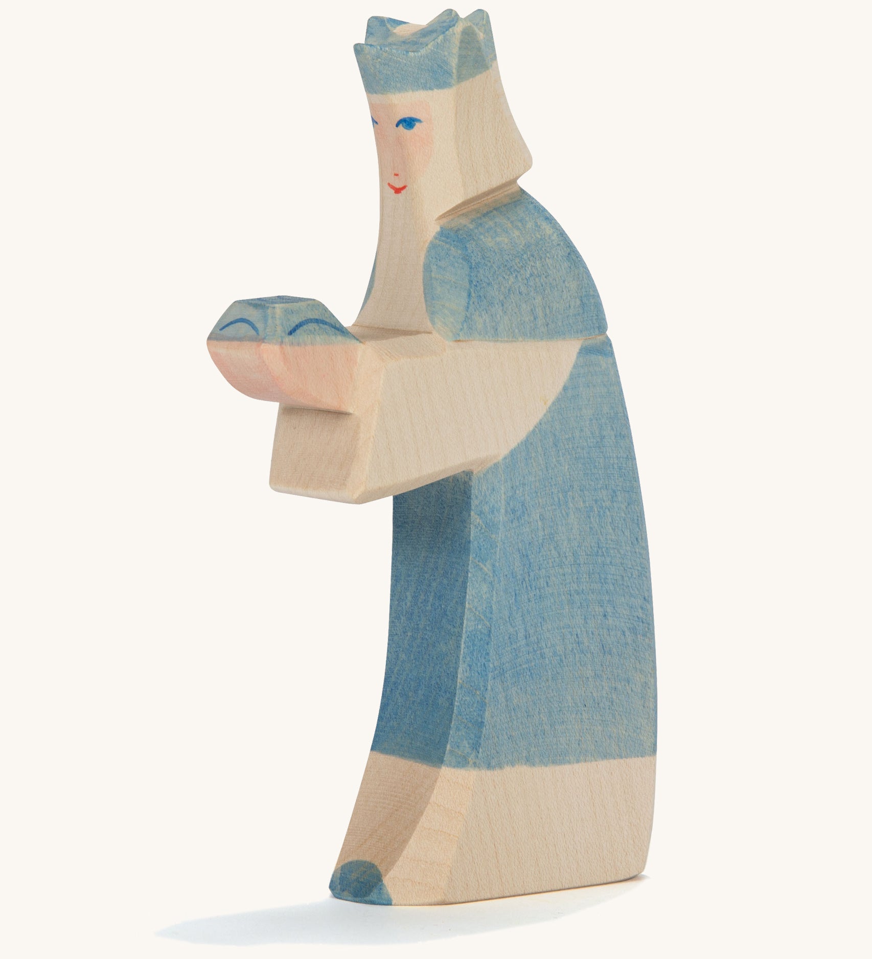 A Ostheimer wooden king figure wearing a blue gown and a blue crown on his head on a cream background.