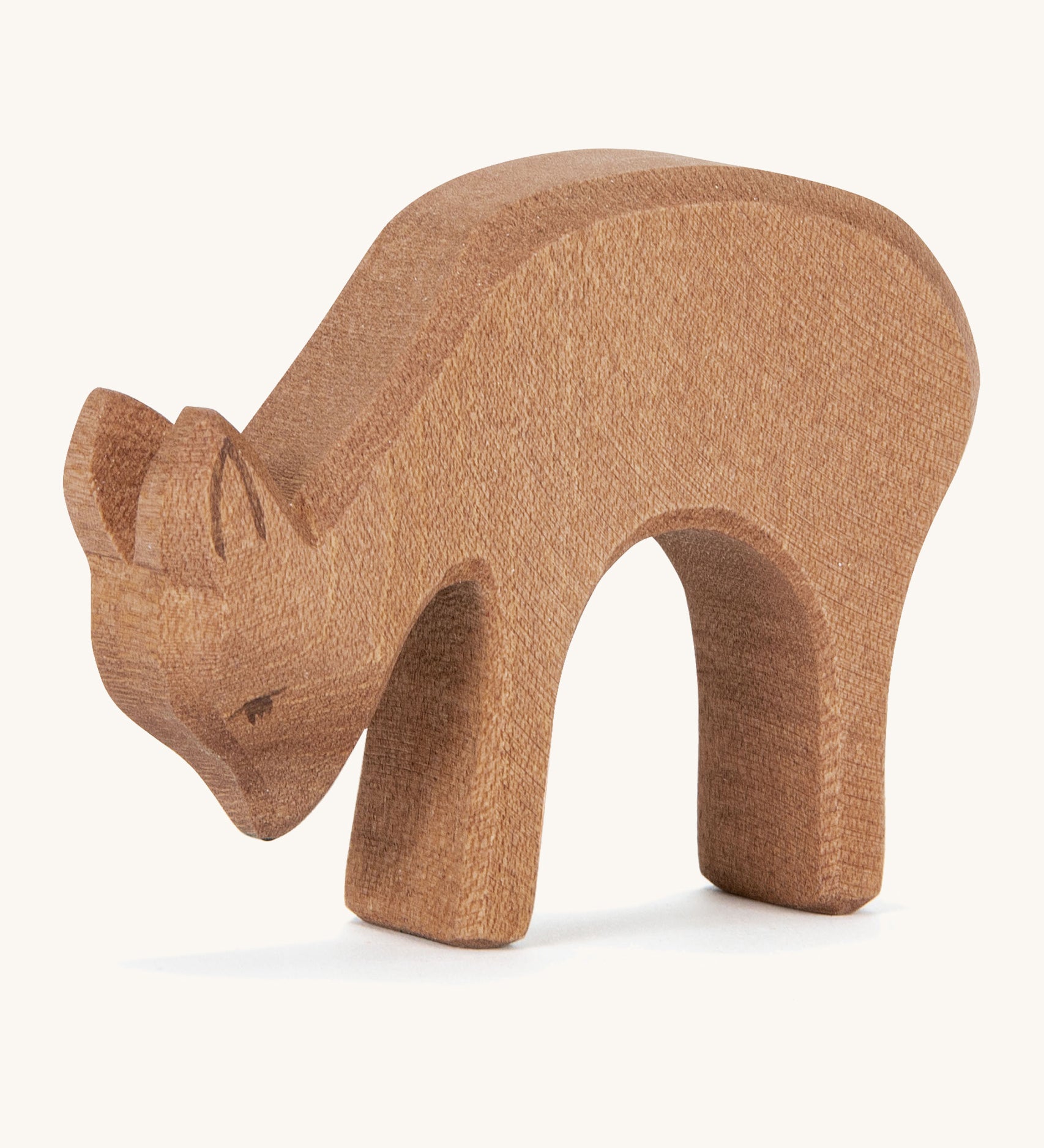 A wooden Ostheimer deer figure eating on a cream background