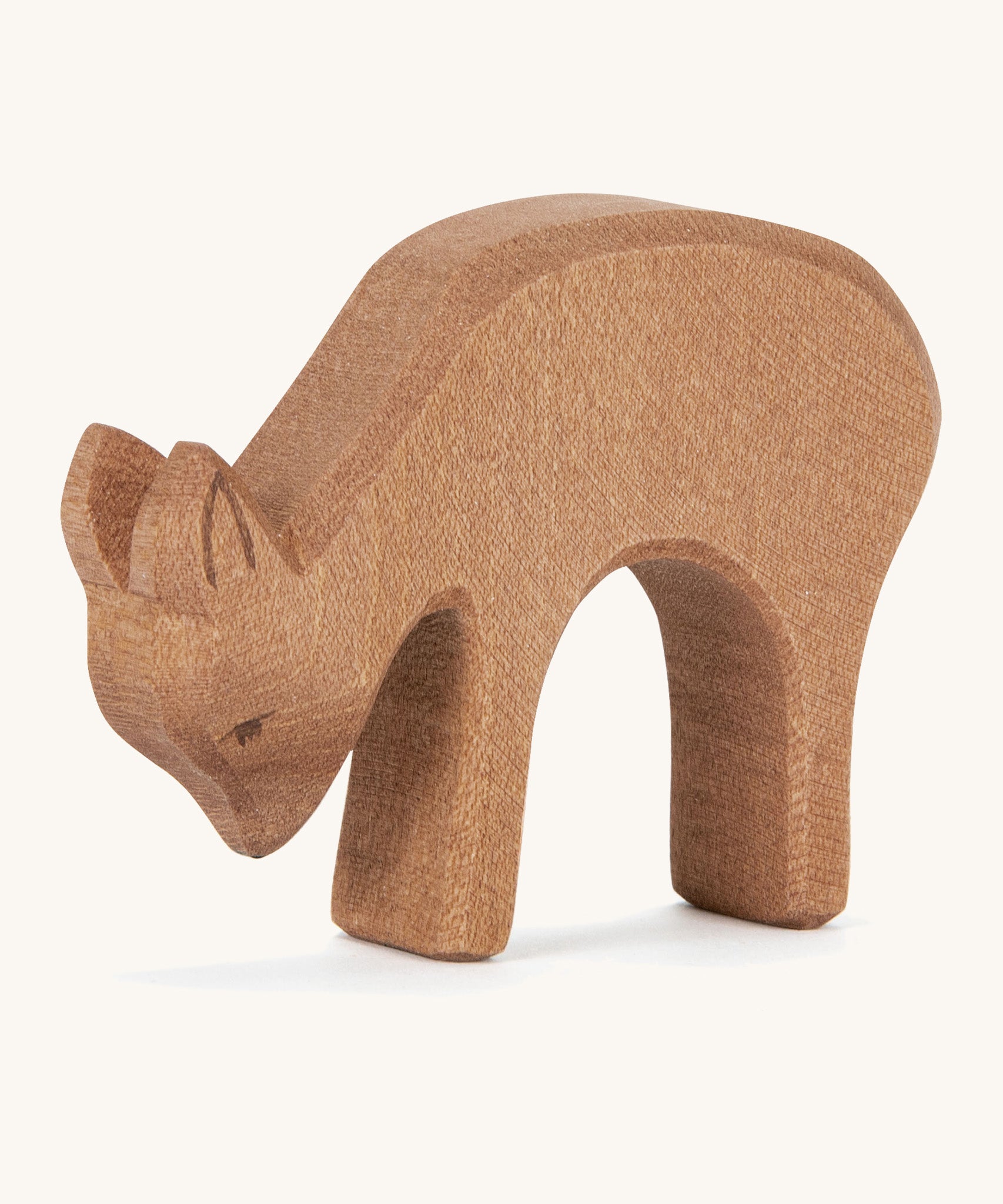 A wooden Ostheimer deer figure eating on a cream background