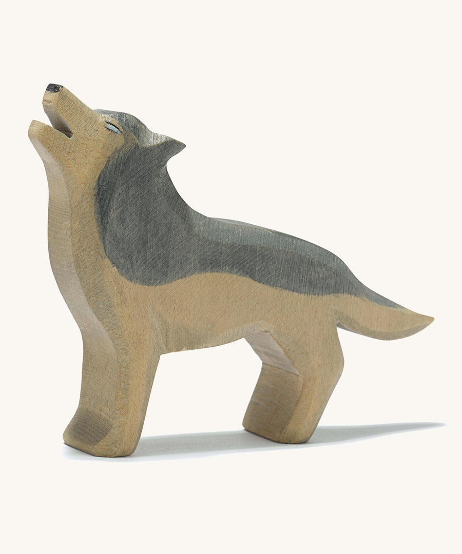 A wooden Ostheimer howling grey wolf figure on a cream background