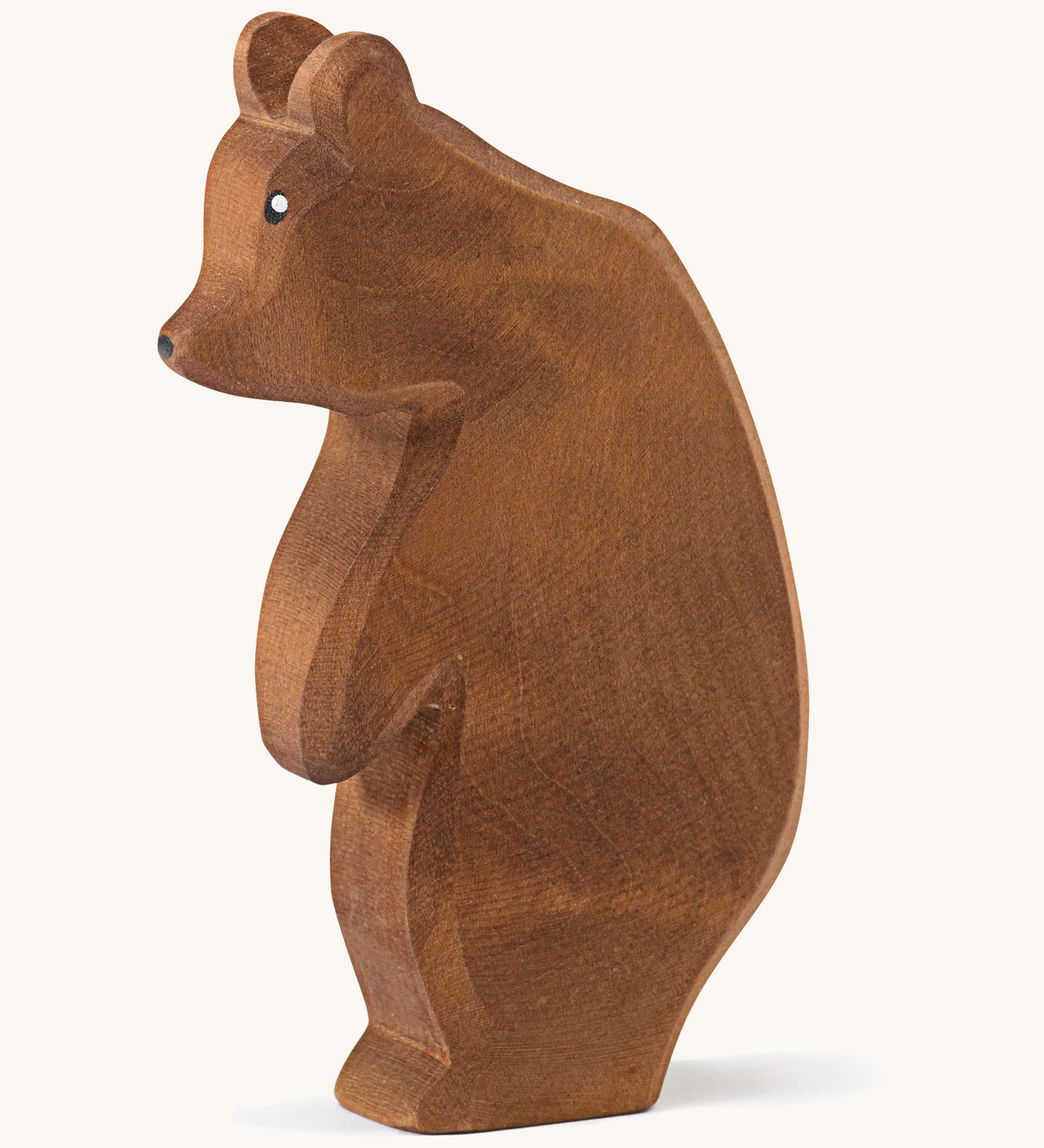  A wooden Ostheimer large brown bear standing on a cream background.