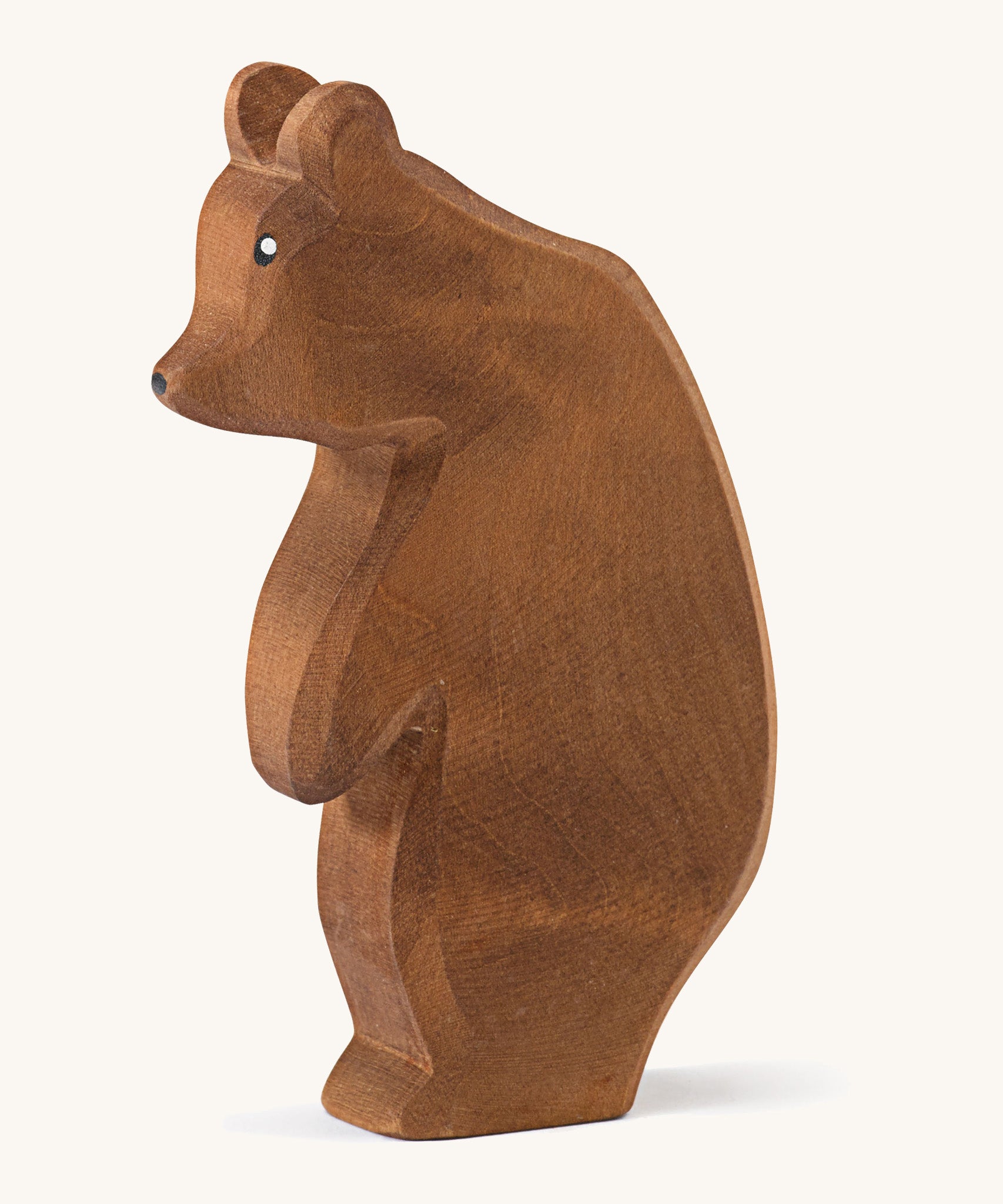  A wooden Ostheimer large brown bear standing on a cream background.