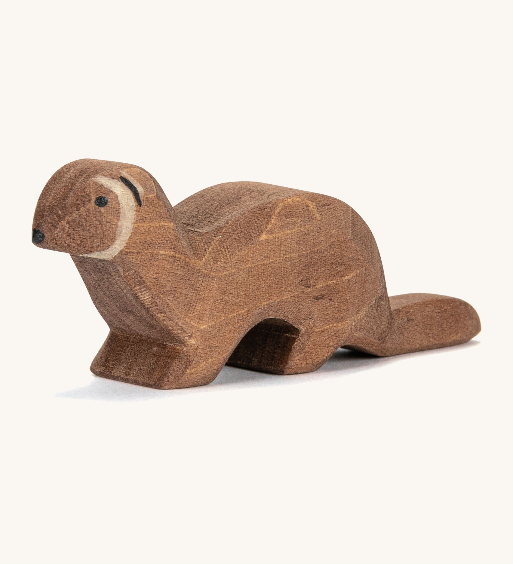 A wooden Ostheimer marten figure on a cream background.