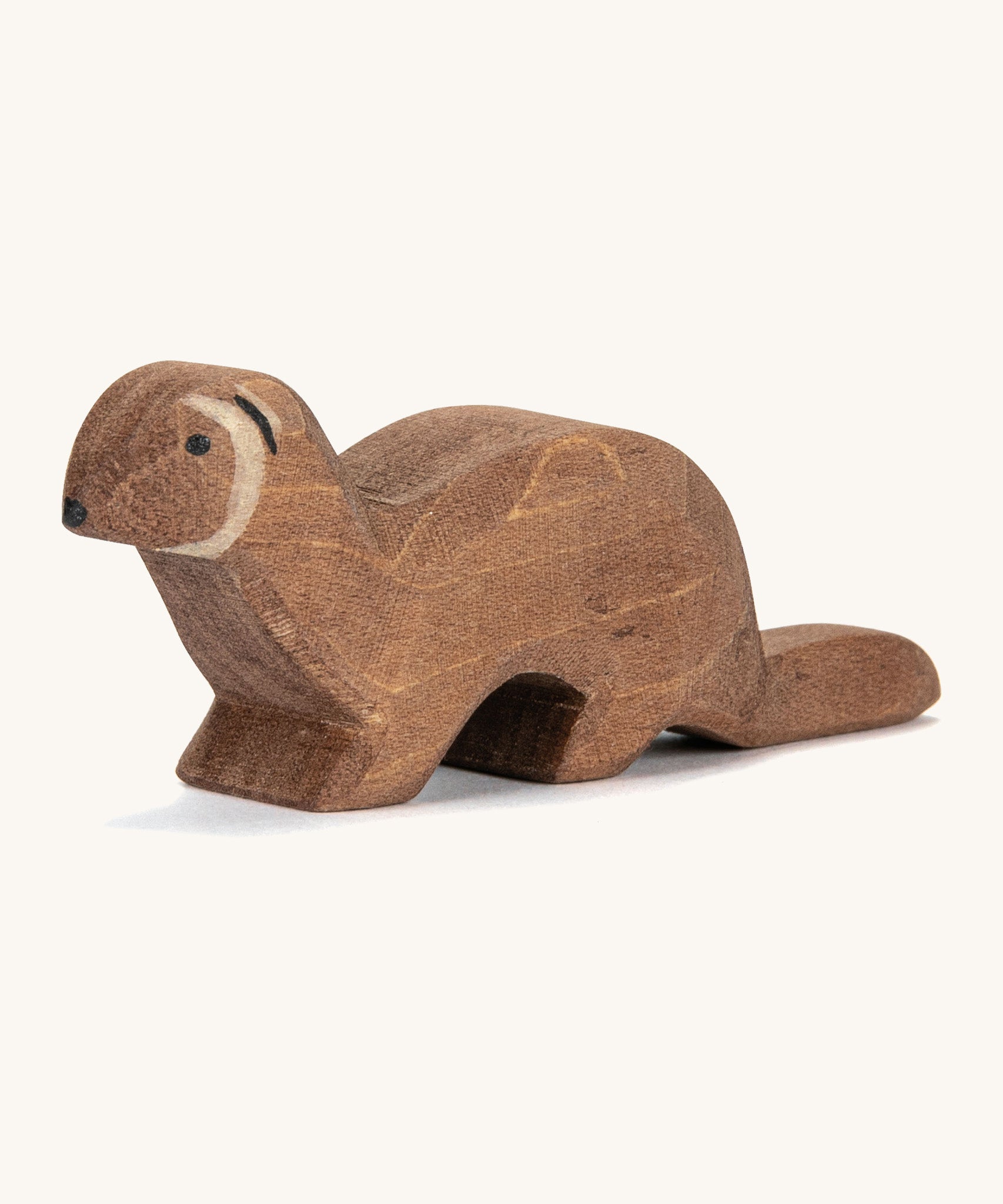 A wooden Ostheimer marten figure on a cream background.