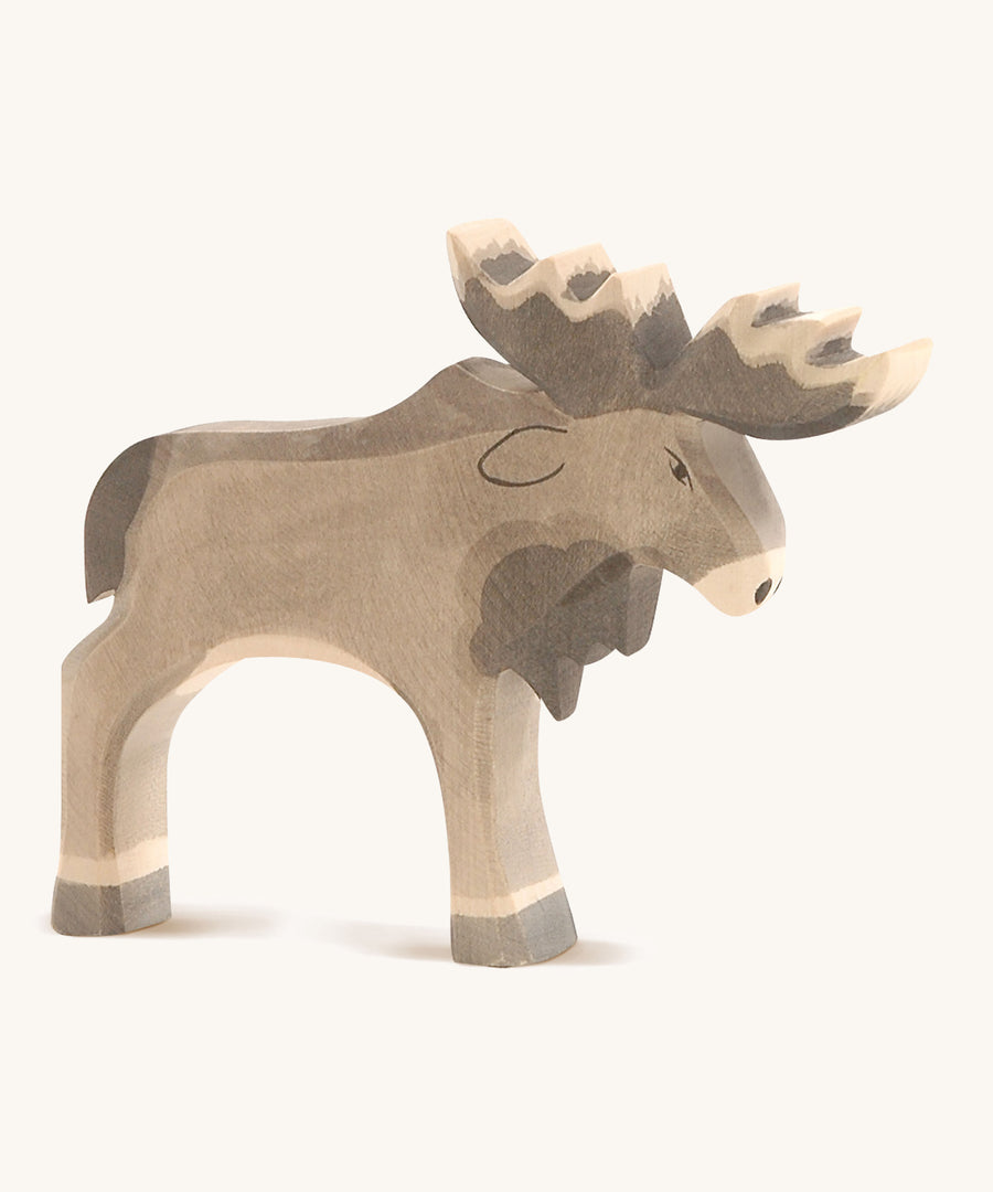 A wooden Ostheimer standing moose figure on a cream background.