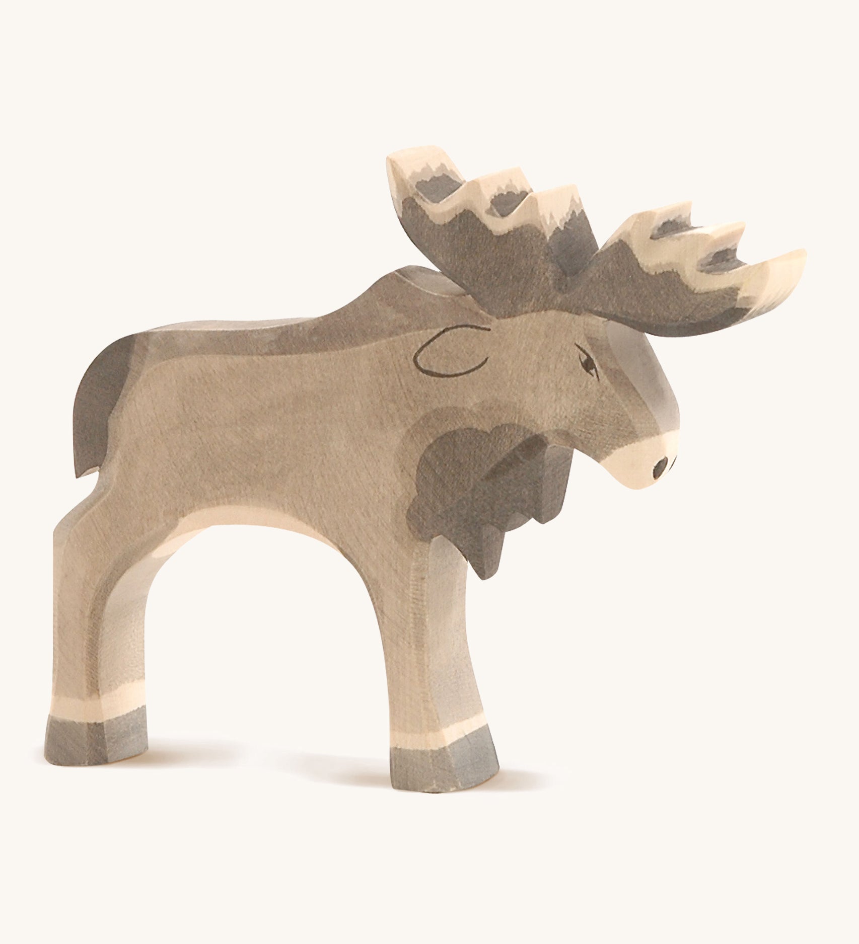 A wooden Ostheimer standing moose figure on a cream background.