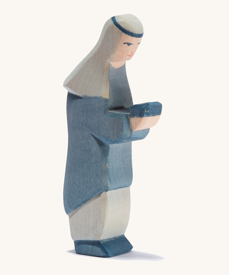 A oriental wooden Ostheimer king figure wearing a blue gown on a cream background.