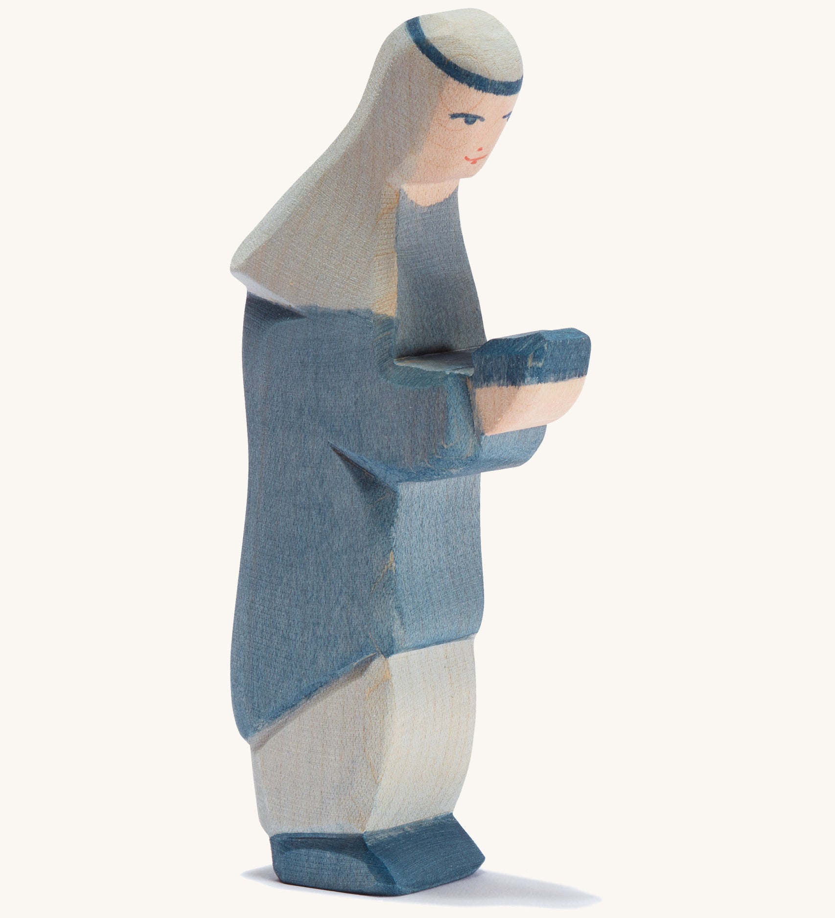 A oriental wooden Ostheimer king figure wearing a blue gown on a cream background.