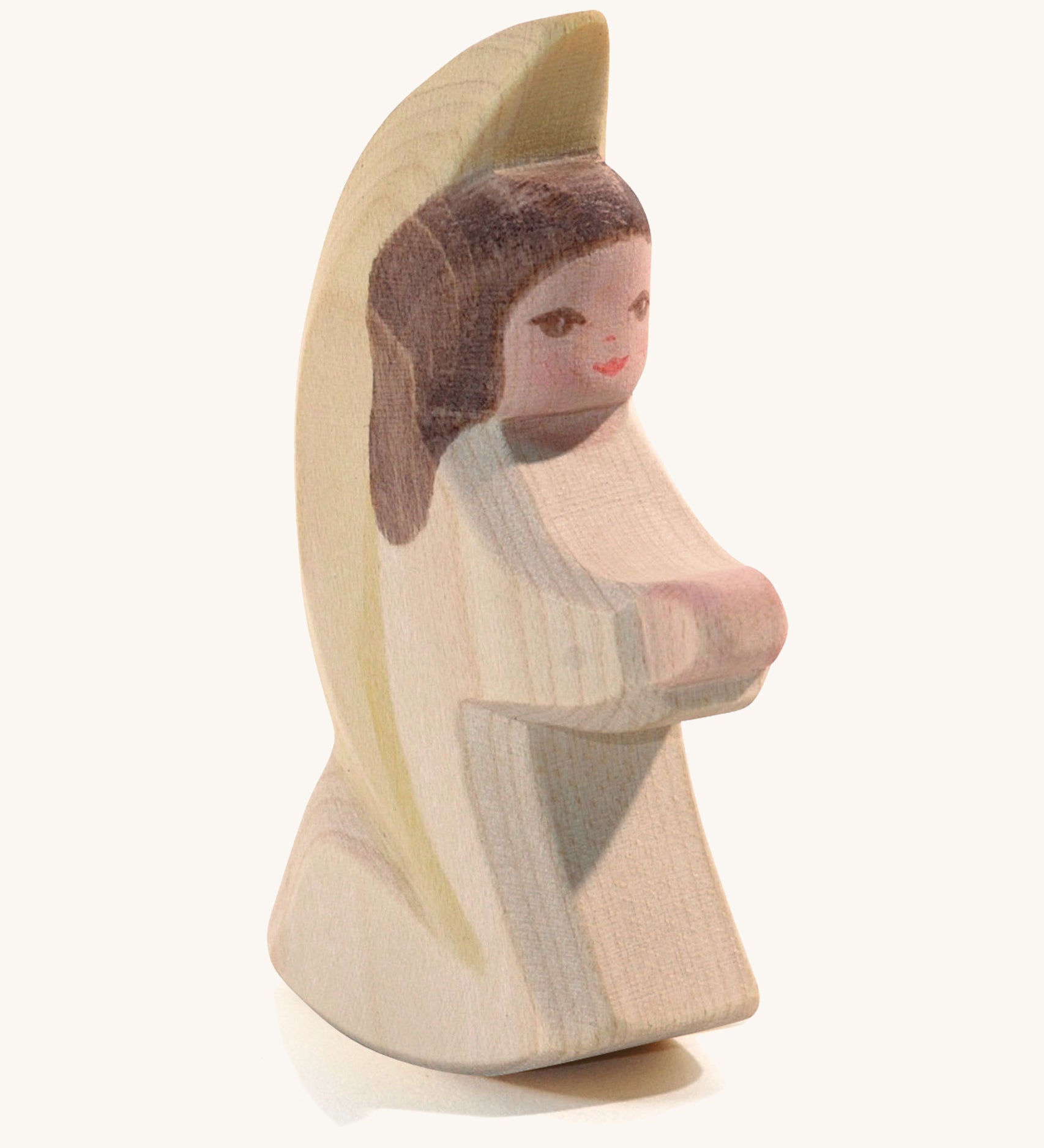 A wooden white Ostheimer little angel figure on a cream background.