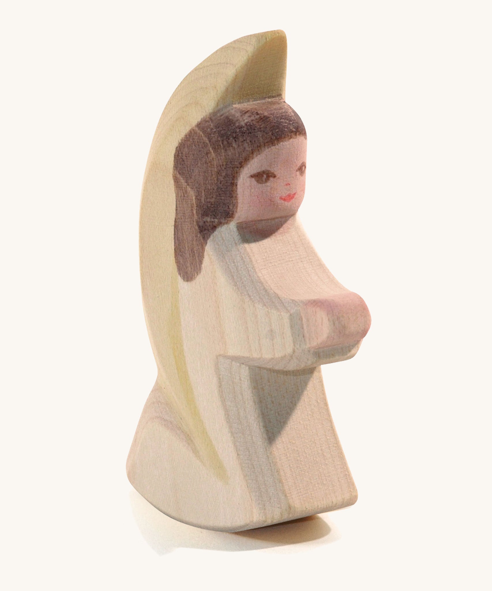 A wooden white Ostheimer little angel figure on a cream background.