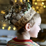 Child wearing a nature crown made with brown paper tape.