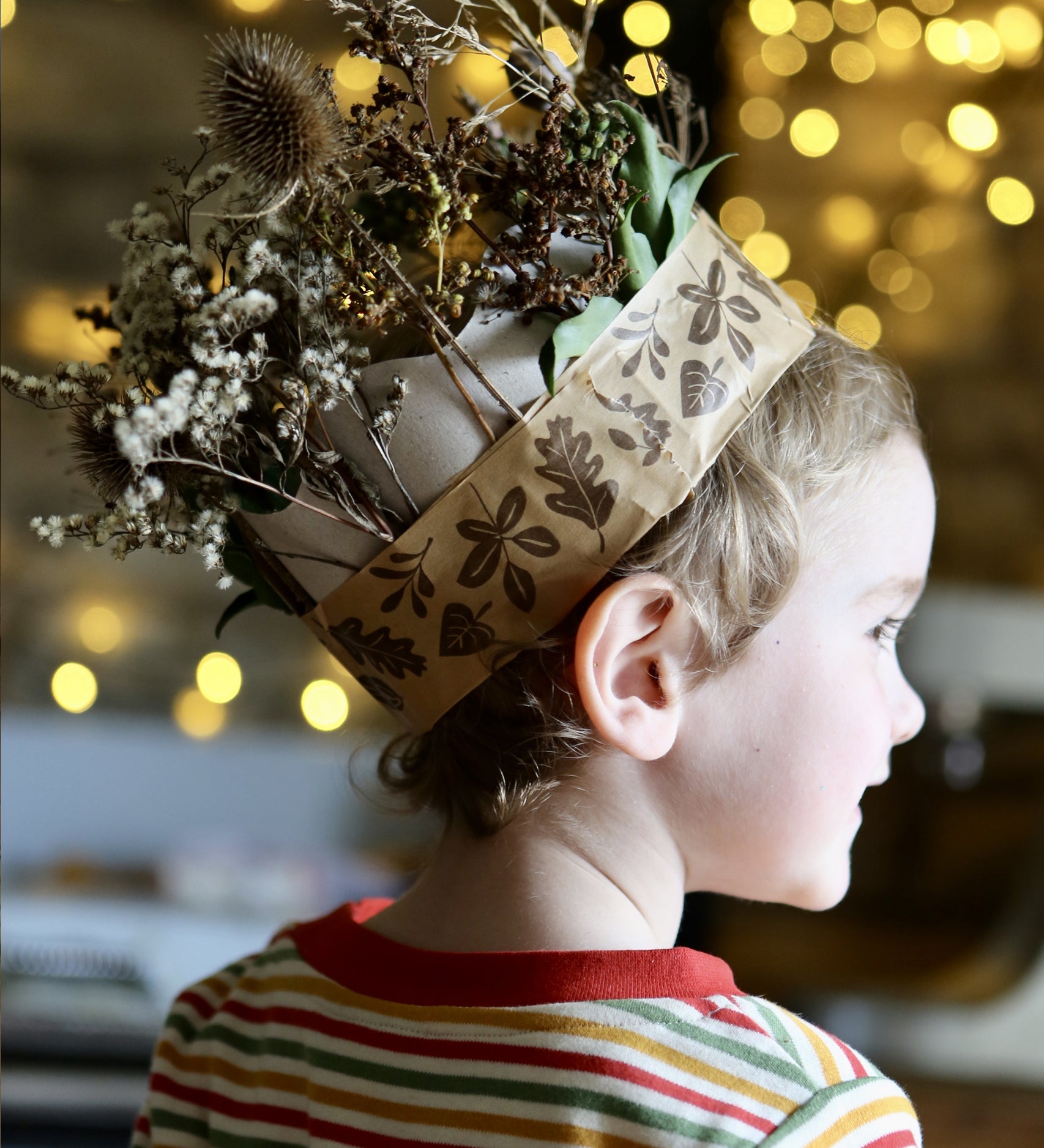 Child wearing a nature crown made with brown paper tape.