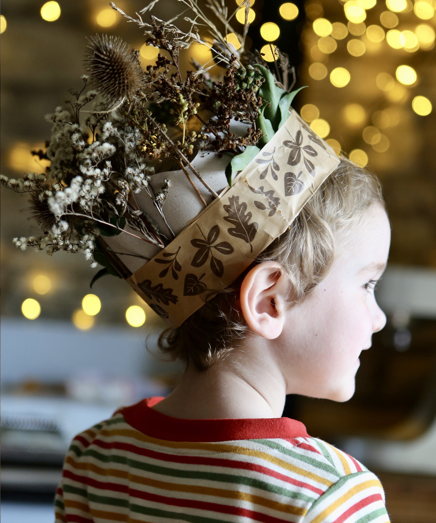 Child wearing a nature crown made with brown paper tape.