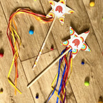 Two cardboard wands on the floor decorated with Babipur tape and ribbon.