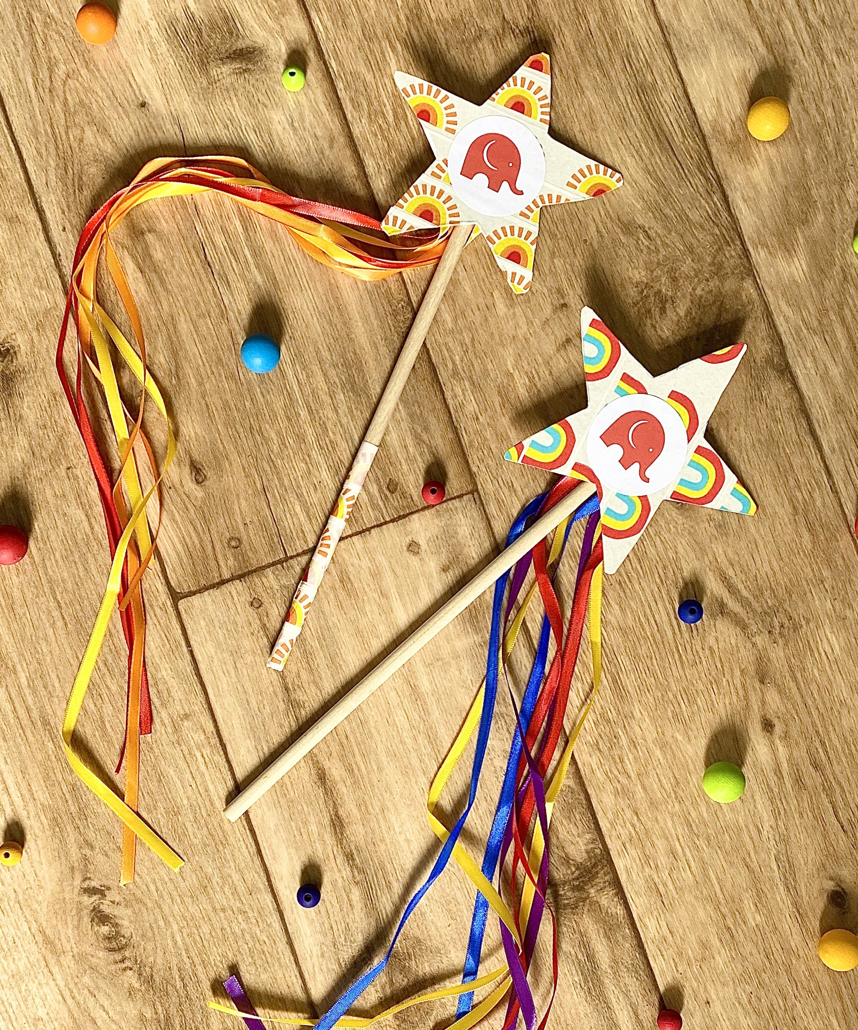 Two cardboard wands on the floor decorated with Babipur tape and ribbon.