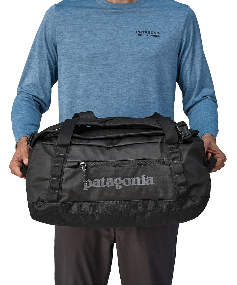 A person holding the Patagonia Black Hole Duffel 40L in their hands to show the size