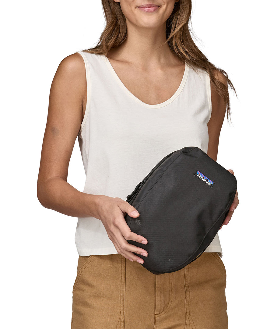 A person holding a Patagonia Black Hole Cube 6L