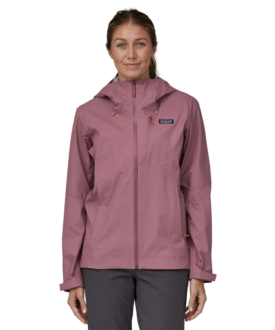 Woman wearing the Patagonia Women's Granite Crest Rain Jacket - Evening Mauve, a solid lilac pink women's hooded rain anorak.