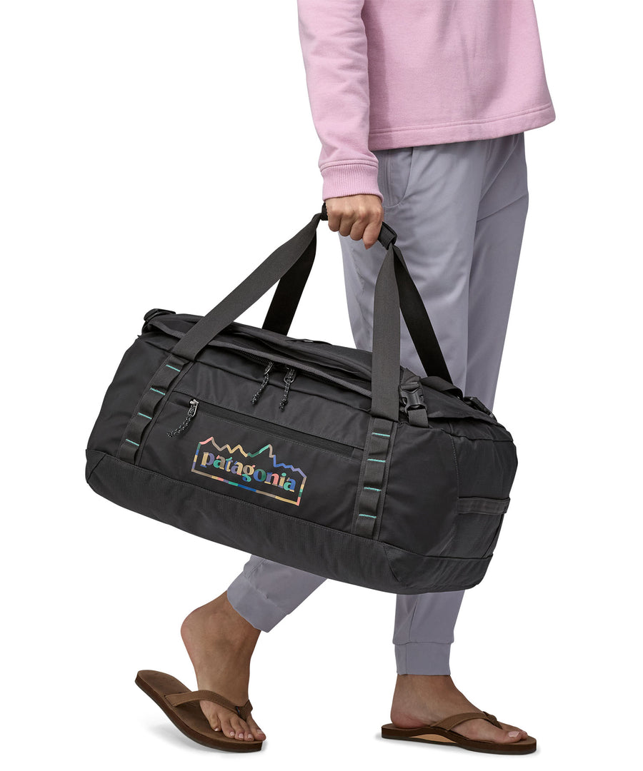 A person carrying the Patagonia Black Hole Duffel 40L with the carry handles