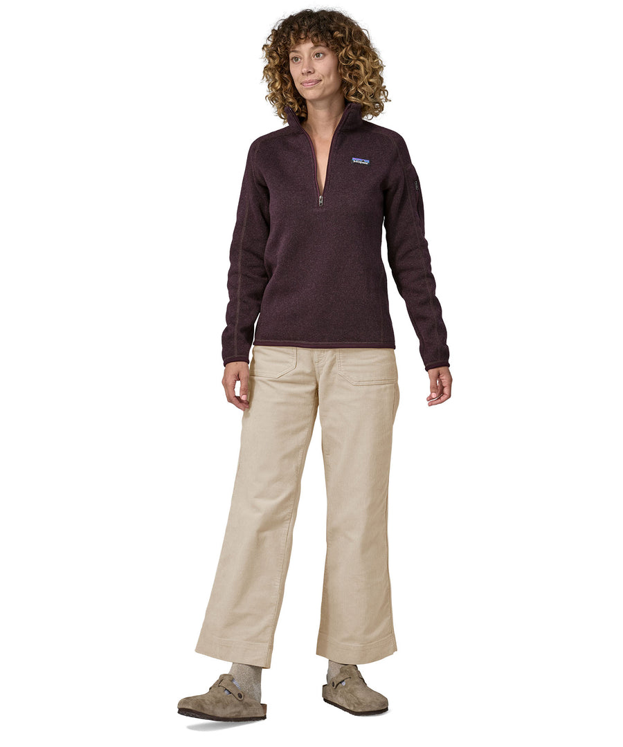 A person wearing the Patagonia Women's Wide Leg Cord Pants - Pumice, with a plum coloured Patagonia Fleece