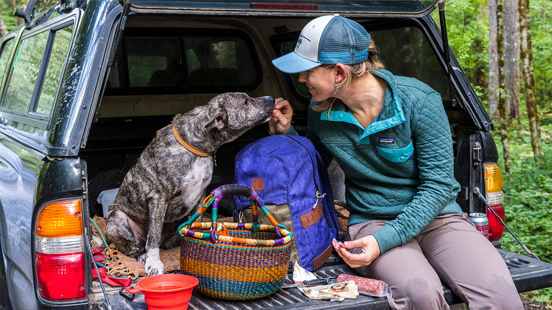 Woman sat in a car with her dog, wearing Patagonia outdoor clothing