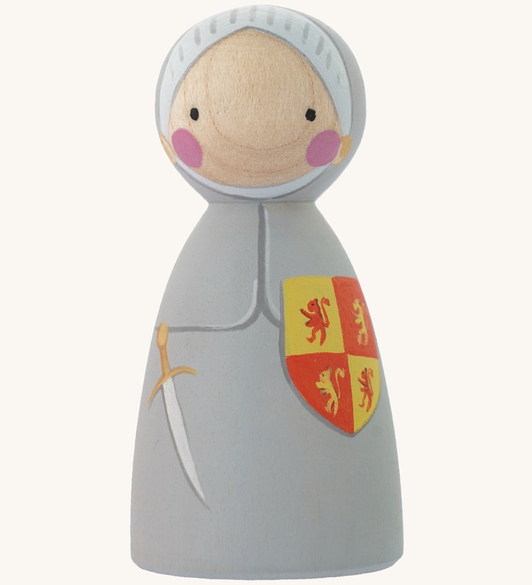 The Peepul plastic-free wooden Owain Glyndwr peg doll toy, is an adorable replica of the Welsh Legand! Owain has a grey hand painted suit of armour and knights helmet, with a red and yellow shield, and painted sword. The image is on a cream background.