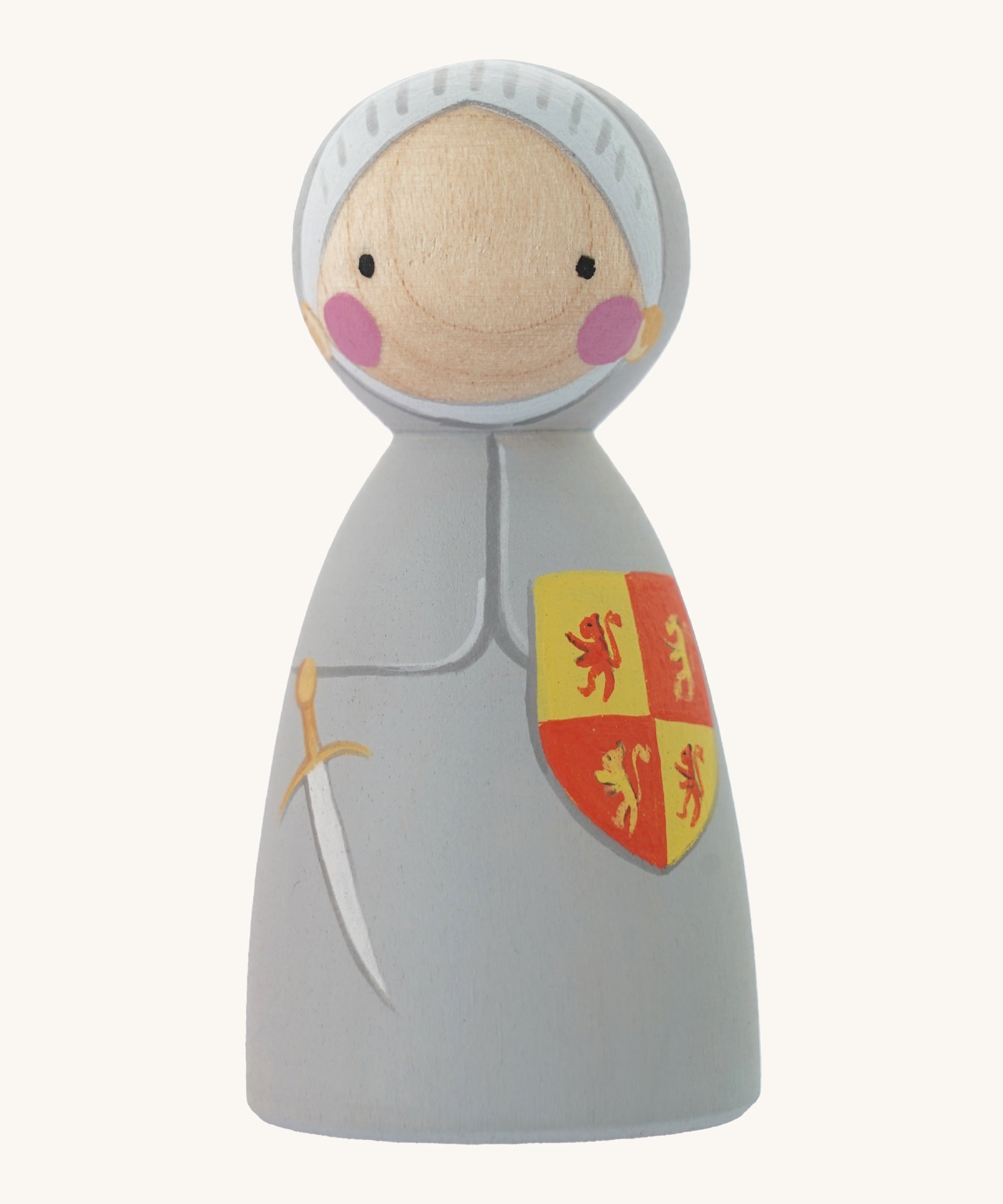 The Peepul plastic-free wooden Owain Glyndwr peg doll toy, is an adorable replica of the Welsh Legand! Owain has a grey hand painted suit of armour and knights helmet, with a red and yellow shield, and painted sword. The image is on a cream background.