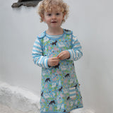 A child wearing the Piccalilly Country Friends Reversible Dress, showing the farm yard animal print