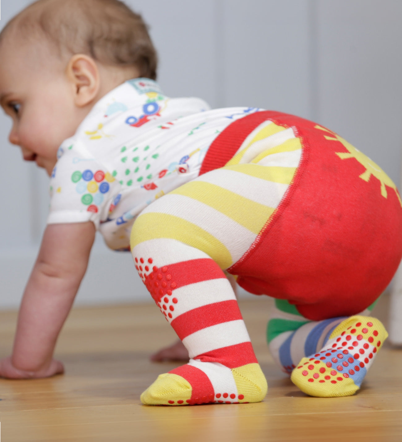 A closer look at the red and yellow stripe, and dot grippers on the Piccalilly Hotchpotch Crawler Tights