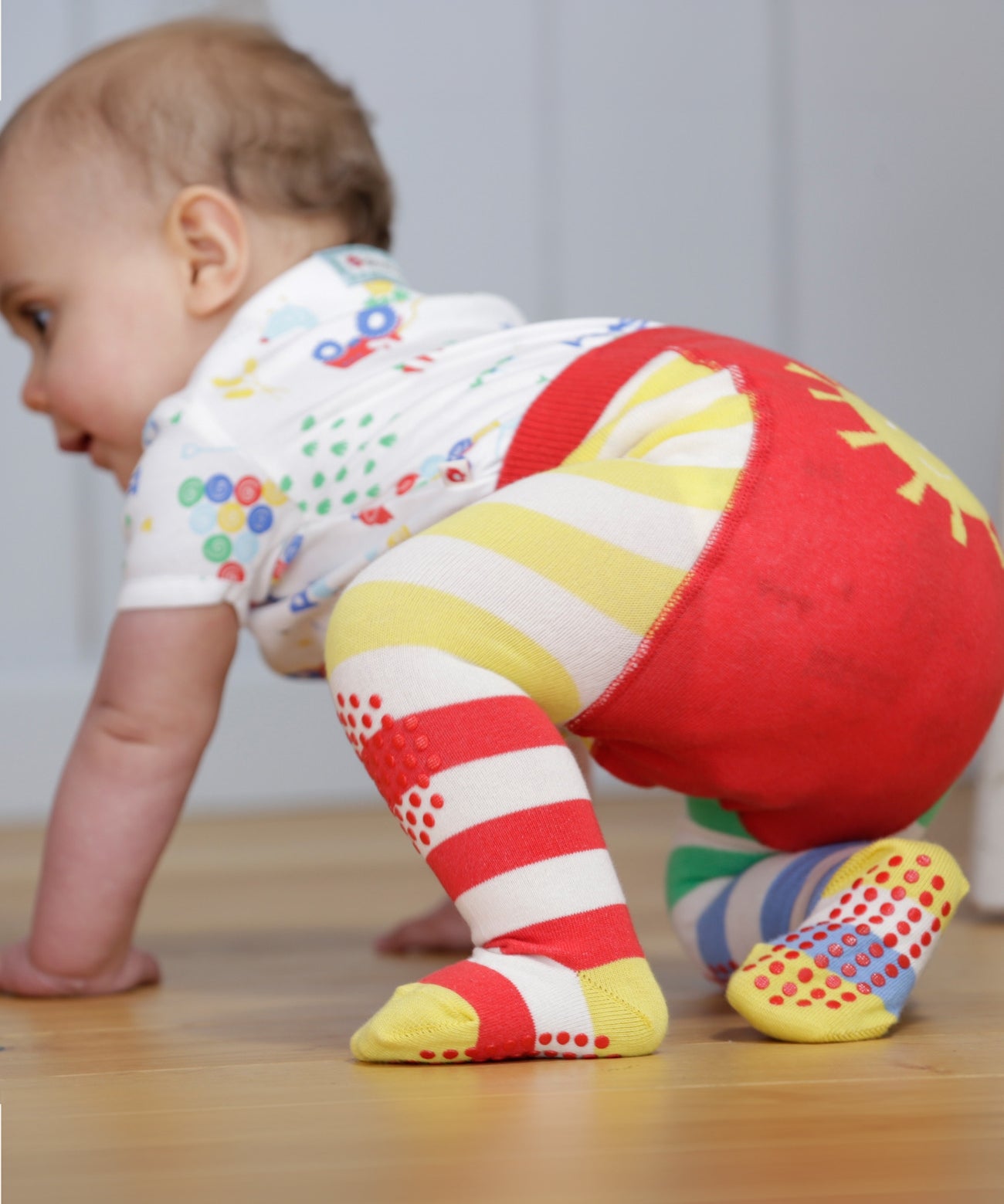 A closer look at the red and yellow stripe, and dot grippers on the Piccalilly Hotchpotch Crawler Tights