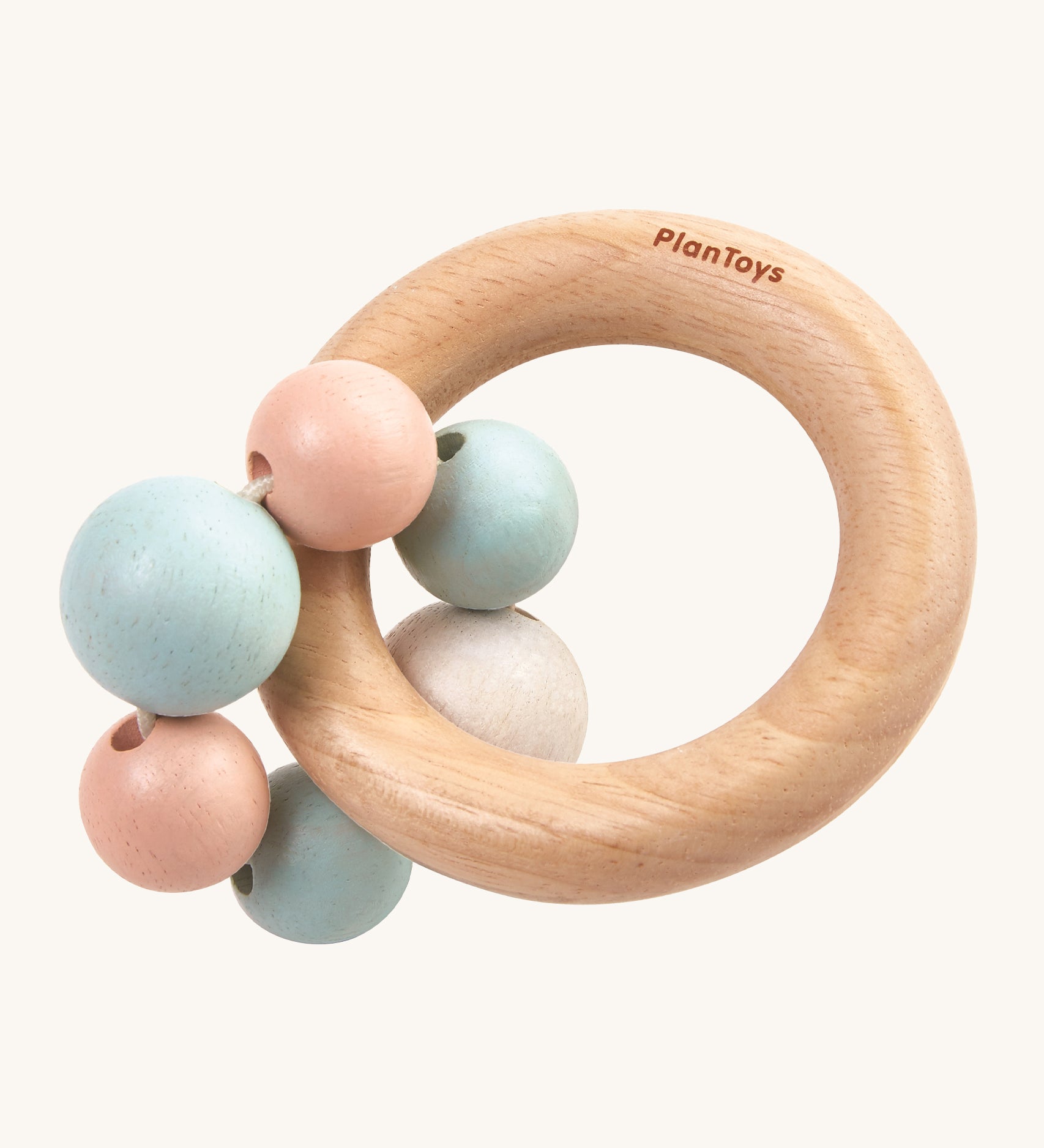 PlanToys Pastel Beads Rattle is a beautifully crafted, wooden baby rattle that is perfect for teething and sore gums. The rattle comes with a wooden ring, and attached to the ring a pastel pink, blue and white beads. The image is on a cream background