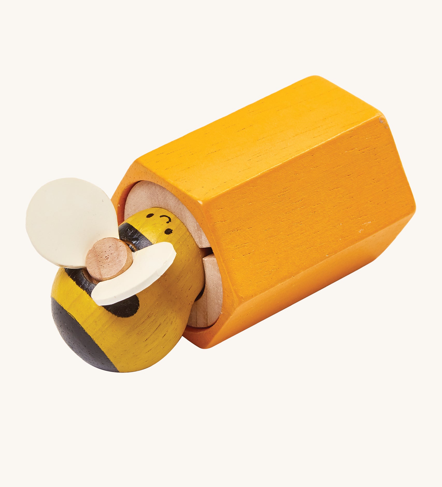 PlanToys Buzz Bee is a wooden grip and pull toy which zooms back into the bee hive once pulled. The hive is yellow, and the bee is yellow and black with cream wings. The image is on a cream background